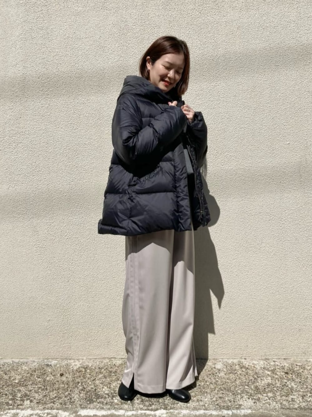 ブラック系のダウンジャケット/コート、ベージュ系のその他パンツ、グレー系のTシャツ/カットソーを着用したレディースの冬コーディネートの4枚目の写真
