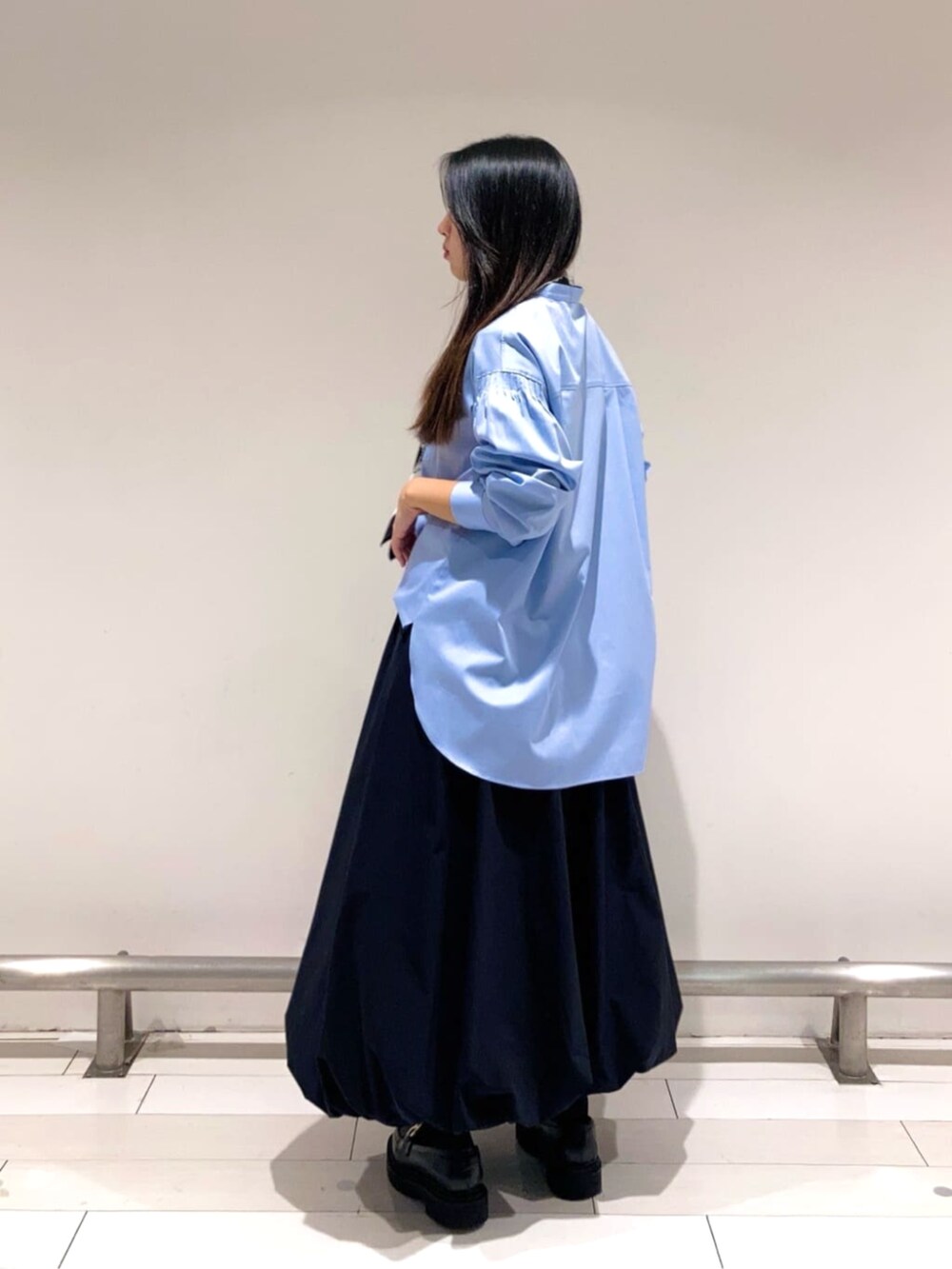 ブラック系のスカート、ブルー系のシャツ/ブラウス、ブラック系のストール/ショールを着用したレディースの春コーディネートの3枚目の写真