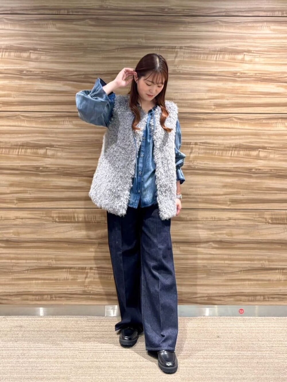 ブラック系のその他シューズ、グレー系のベスト、ブルー系のデニムパンツを着用したレディースの秋コーディネートの2枚目の写真