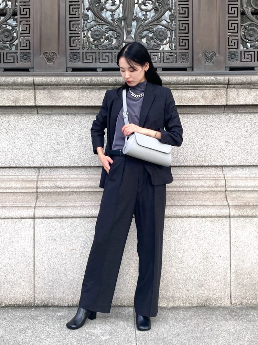 グレー系のスーツジャケット、グレー系のスーツパンツ、グレー系のショルダーバッグを着用したレディースの秋コーディネートの3枚目の写真