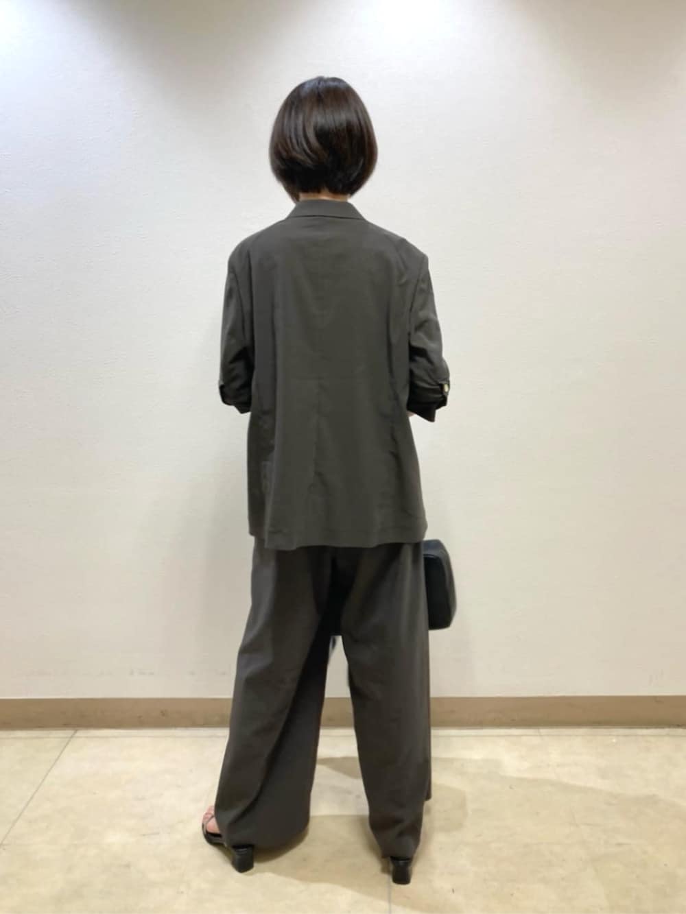 グレー系のテーラードジャケット、グレー系のその他パンツ、ホワイト系のニット/セーターを着用したレディースの春コーディネートの3枚目の写真