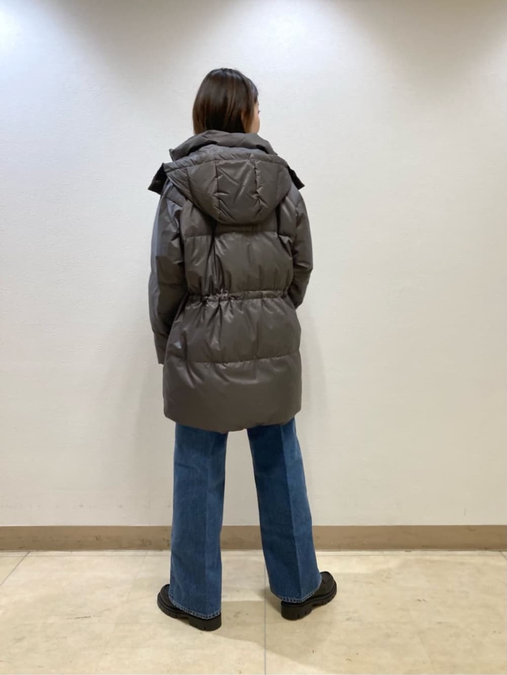 ブルー系のデニムパンツ、グレー系のダウンジャケット/コート、ベージュ系のカーディガン/ボレロを着用したレディースの冬コーディネートの6枚目の写真