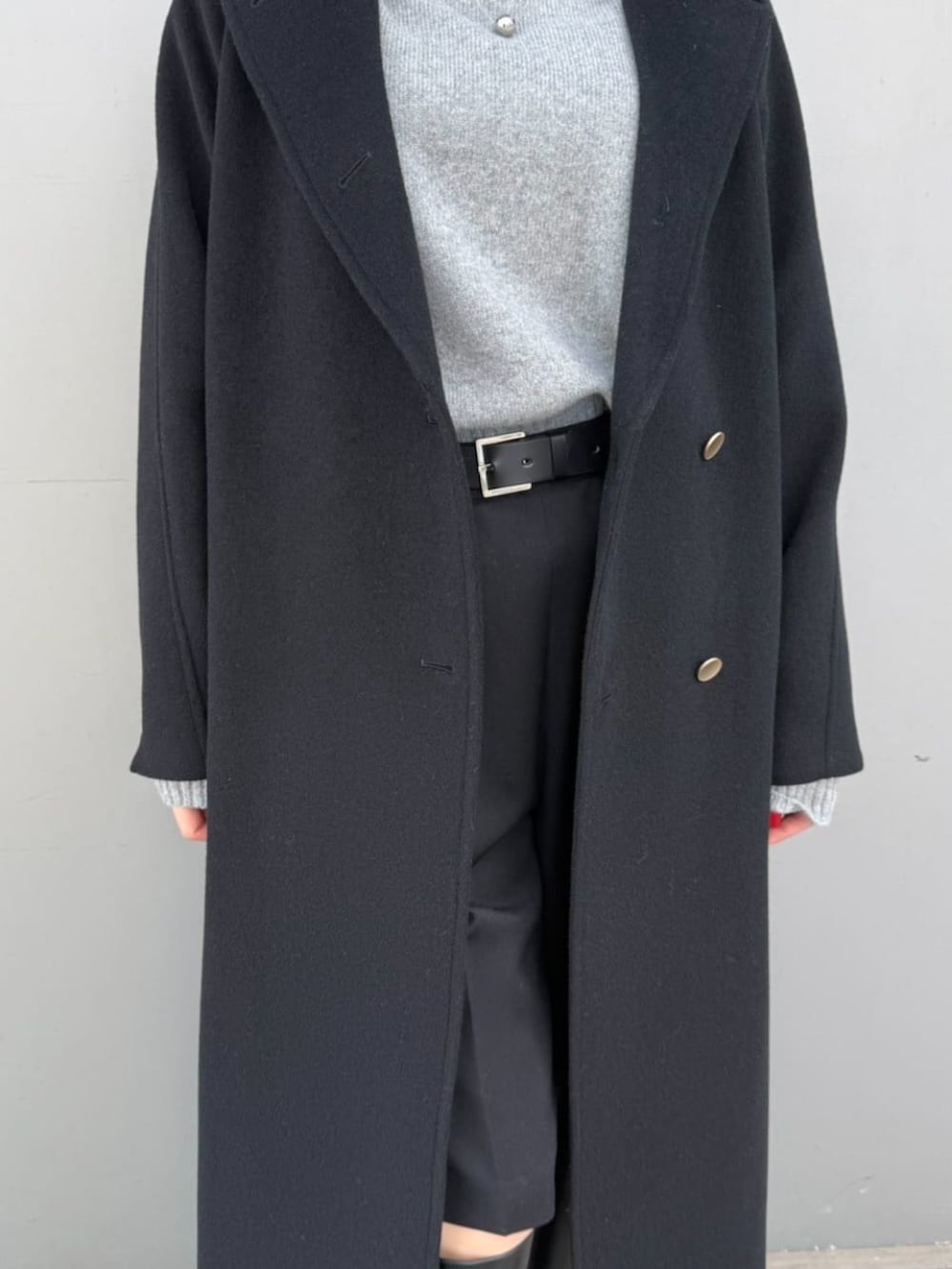 ブラック系のトレンチコート、グレー系のニット/セーターを着用したレディースの冬コーディネートの4枚目の写真