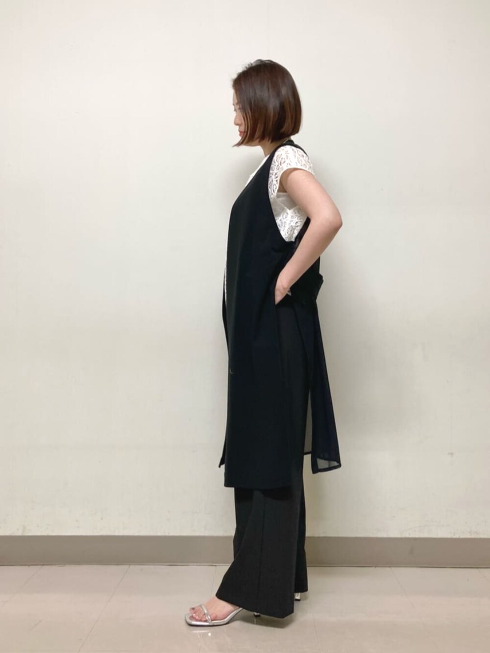 ブラック系のベスト、ホワイト系のシャツ/ブラウス、ブラック系のその他パンツを着用したレディースの春コーディネートの3枚目の写真