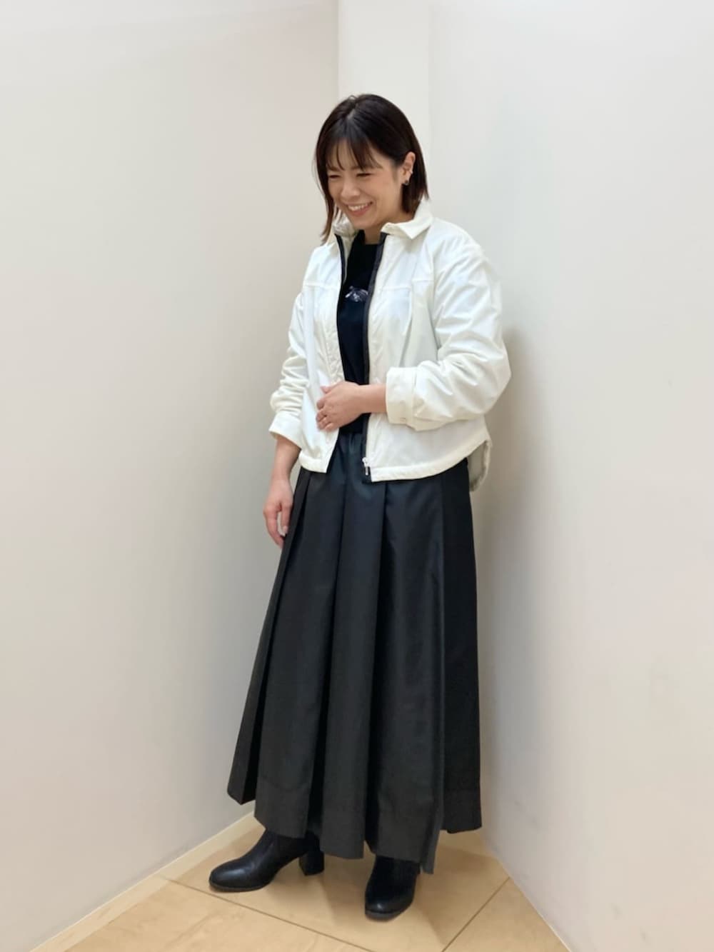 ホワイト系のブルゾンを着用したレディースの夏コーディネートの2枚目の写真