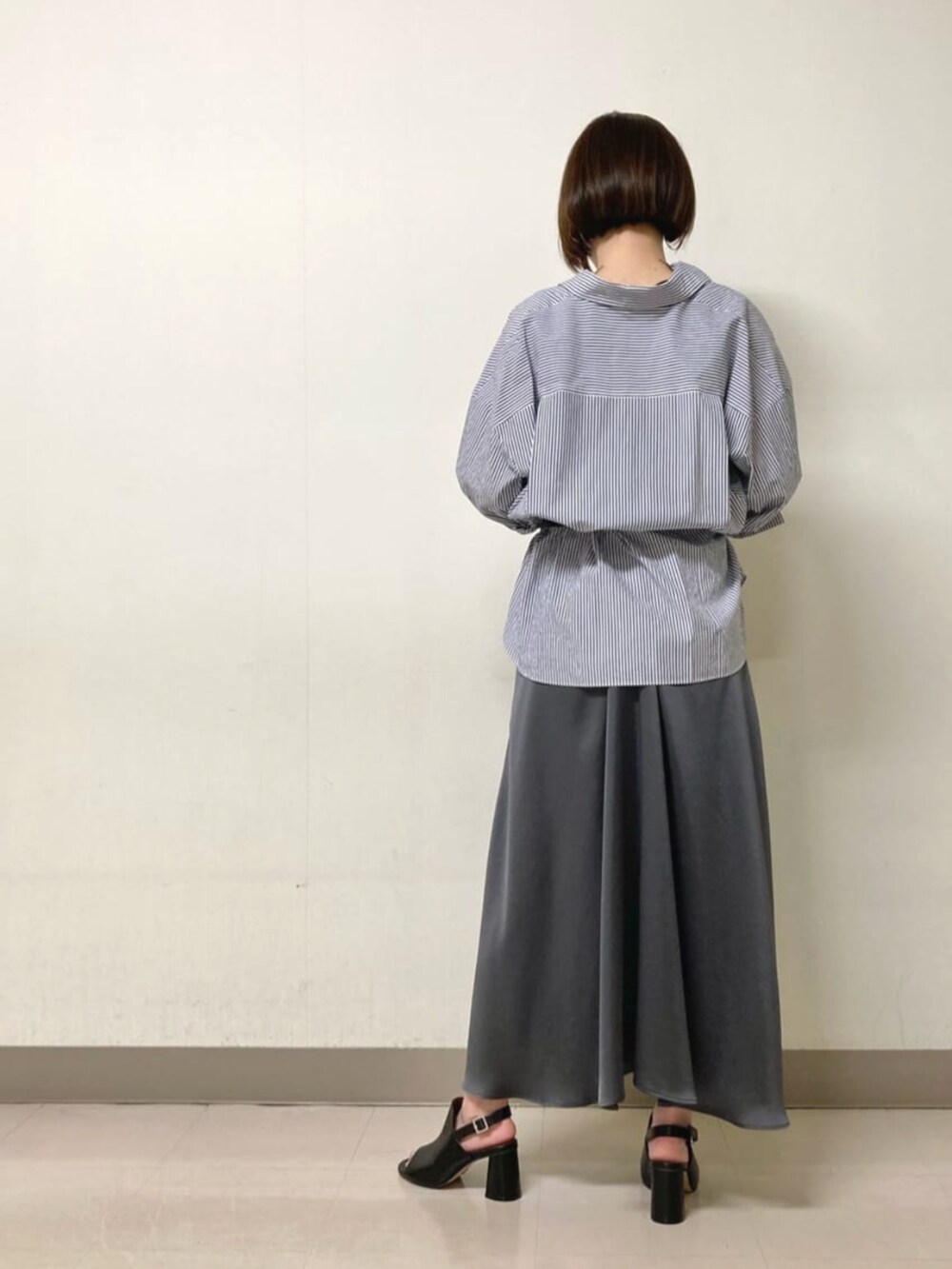 グレー系のワンピース、ブラック系のサンダル、ブルー系のシャツ/ブラウスを着用したレディースの春コーディネートの4枚目の写真