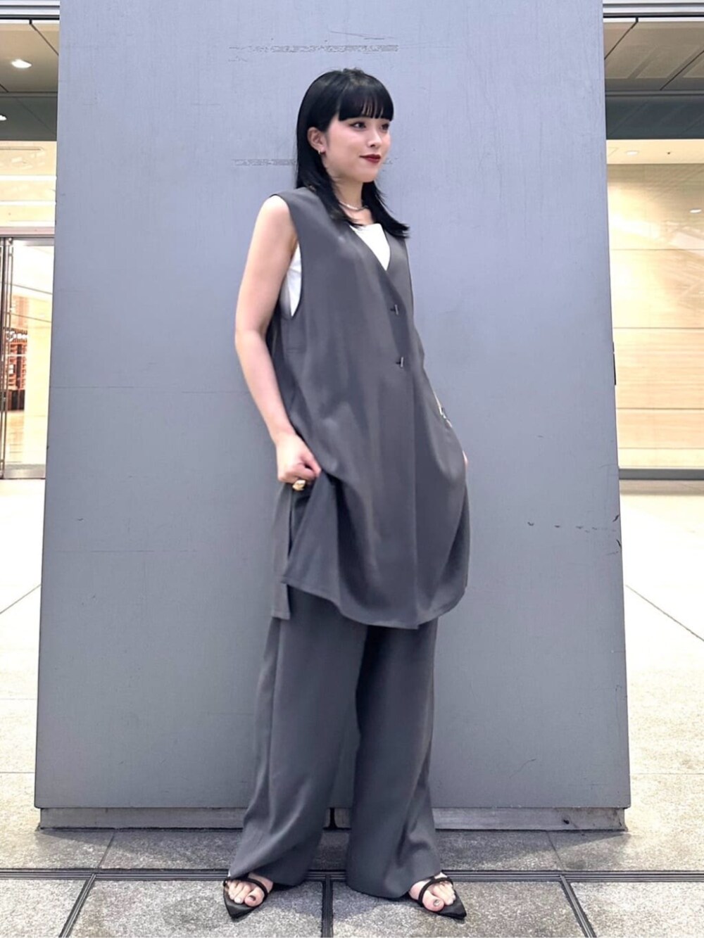 グレー系のベスト、グレー系のパンツを着用したレディースの夏コーディネートの2枚目の写真