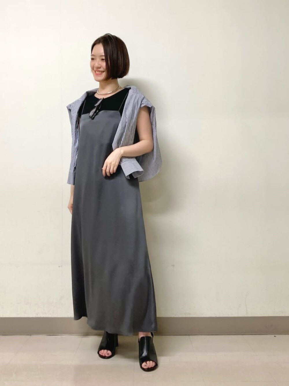 グレー系のワンピース、ブラック系のサンダル、ブルー系のシャツ/ブラウスを着用したレディースの春コーディネートの7枚目の写真