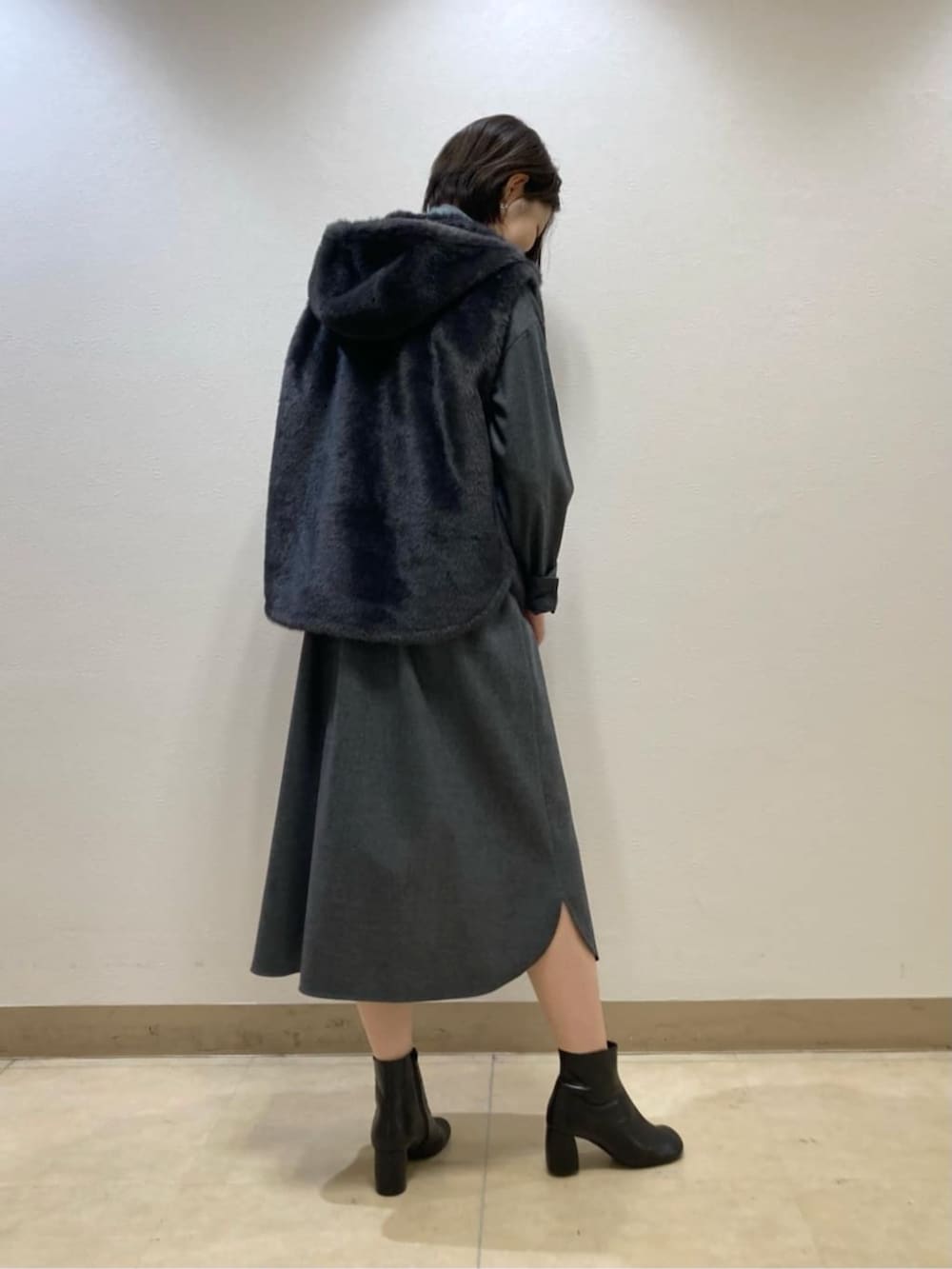 グレー系のベスト、グレー系のワンピースを着用したレディースの秋コーディネートの4枚目の写真