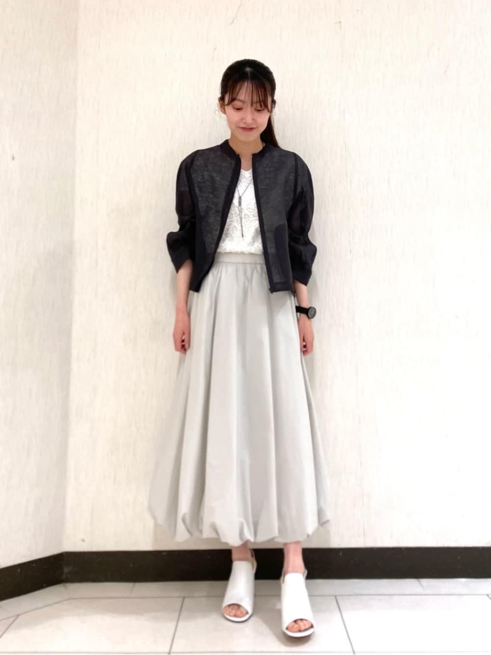 ホワイト系のサンダル、ホワイト系のシャツ/ブラウス、グレー系のスカートを着用したレディースの夏コーディネートの3枚目の写真