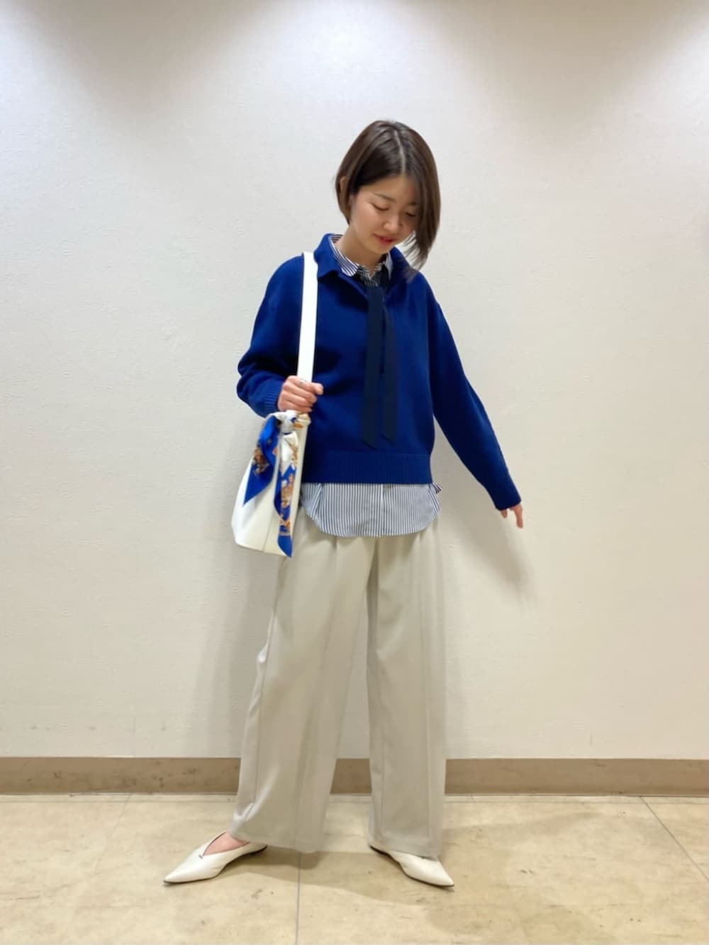 ブルー系のニット/セーター、ベージュ系のその他パンツ、ホワイト系のパンプスを着用したレディースの冬コーディネートの2枚目の写真