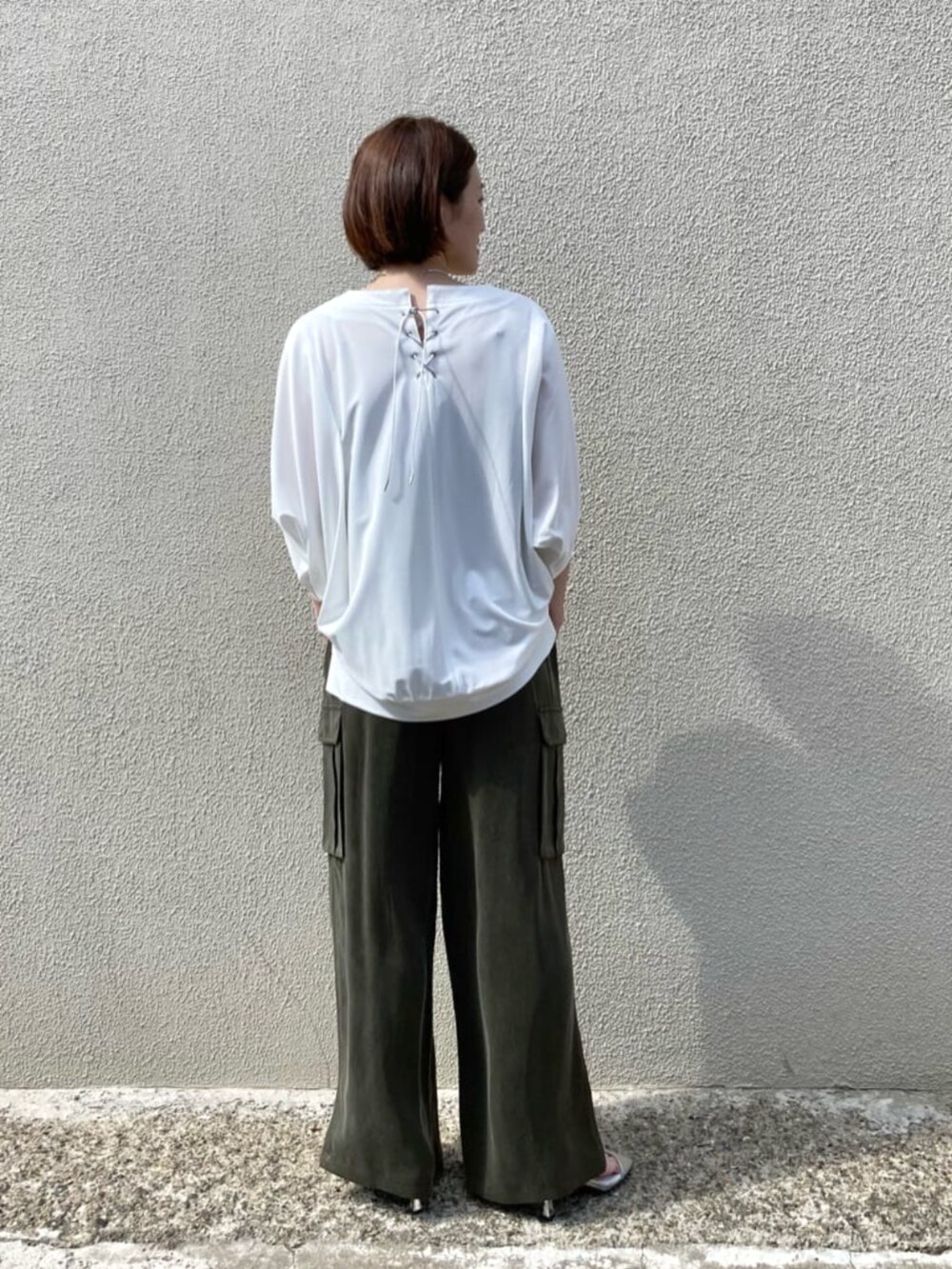 グリーン系のパンツ、ホワイト系のトップスを着用したレディースの夏コーディネートの5枚目の写真