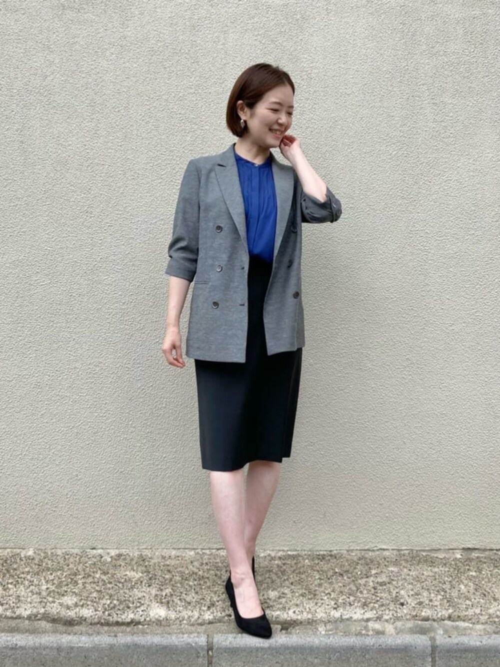 ブルー系のシャツ/ブラウス、グレー系のテーラードジャケット、ブラック系のスーツスカートを着用したレディースの秋コーディネートの3枚目の写真