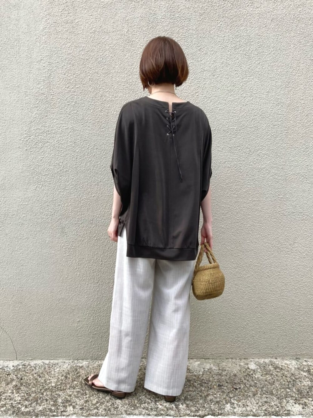 ホワイト系のスラックス、シルバー系のネックレスを着用したレディースの夏コーディネートの4枚目の写真