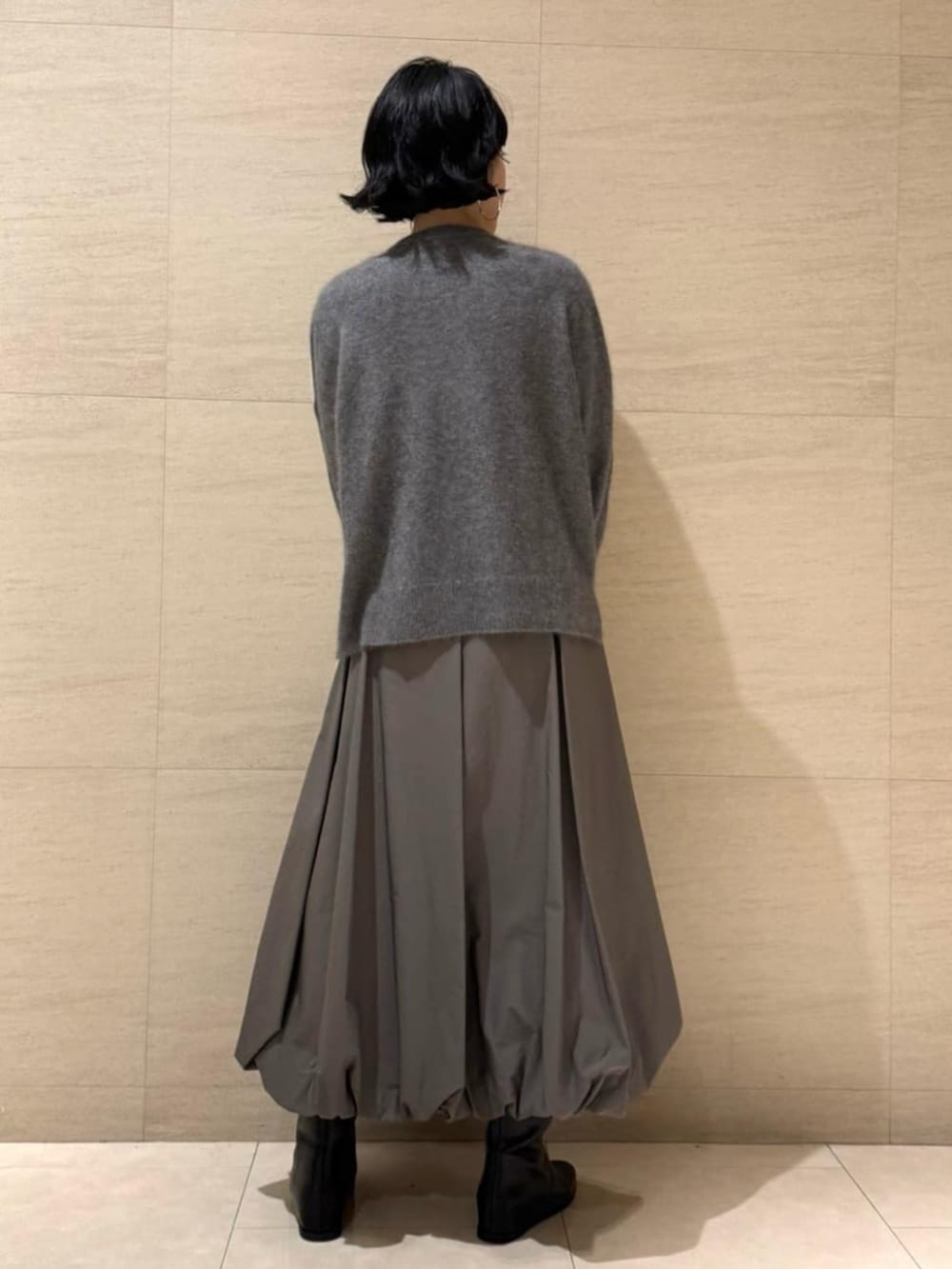 グレー系のチェスターコート、グリーン系のスカートを着用したレディースの冬コーディネートの5枚目の写真