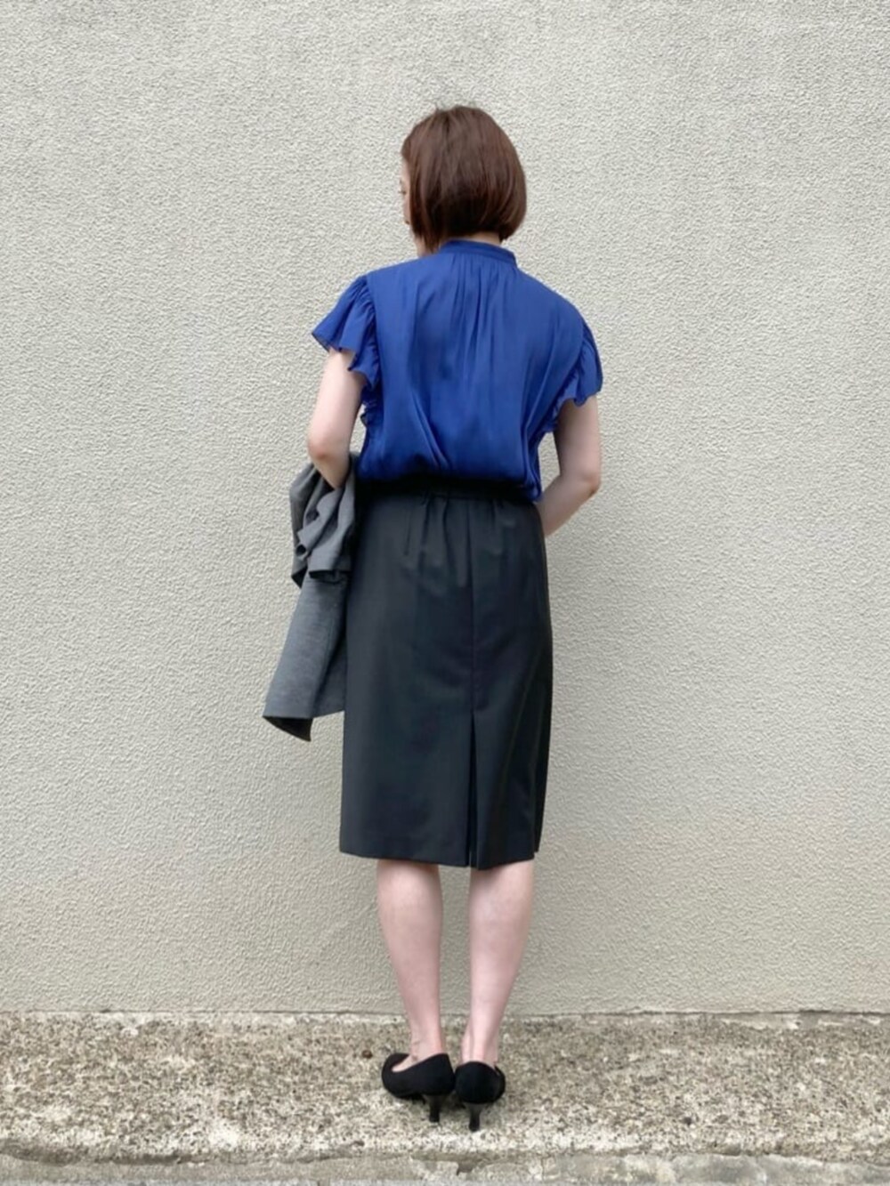 ブルー系のシャツ/ブラウス、グレー系のテーラードジャケット、ブラック系のスーツスカートを着用したレディースの秋コーディネートの8枚目の写真