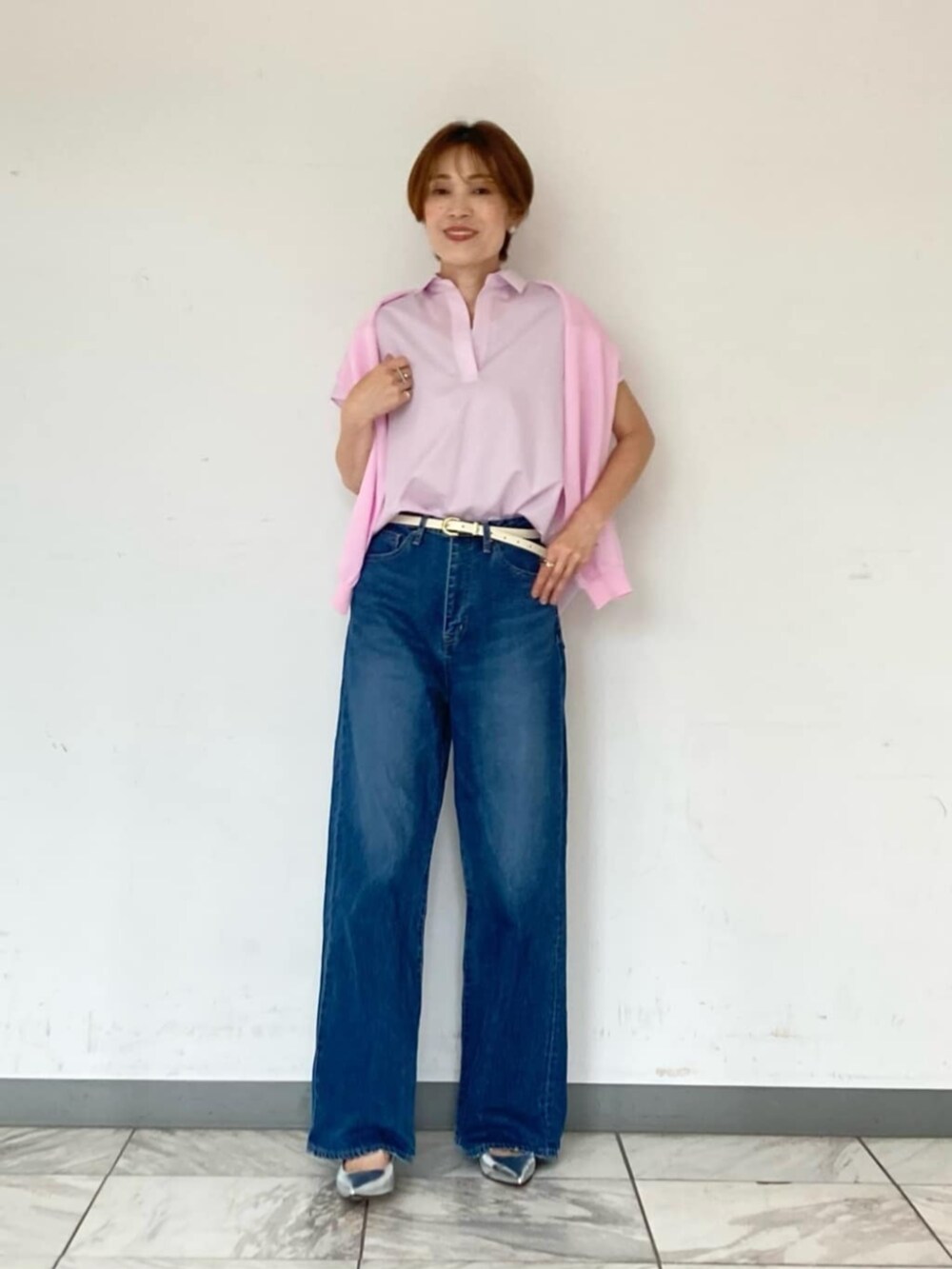 シルバー系のパンプス、ブルー系のデニムパンツ、ピンク系のシャツ/ブラウスを着用したレディースの夏コーディネートの2枚目の写真