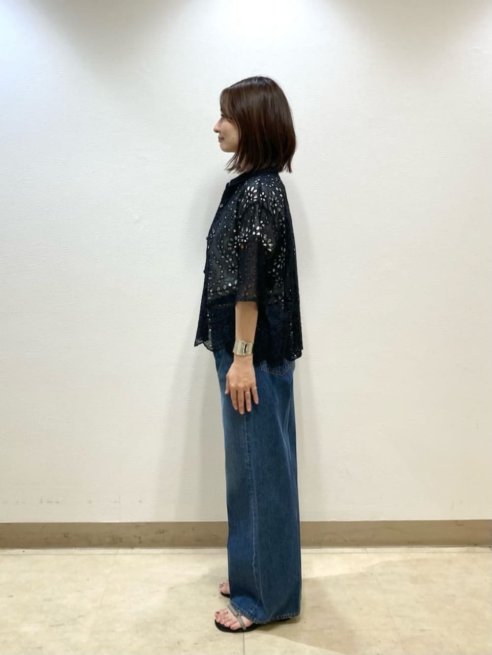 ブルー系のデニムパンツ、ブラック系のシャツ/ブラウス、グレー系のサンダルを着用したレディースの春コーディネートの4枚目の写真