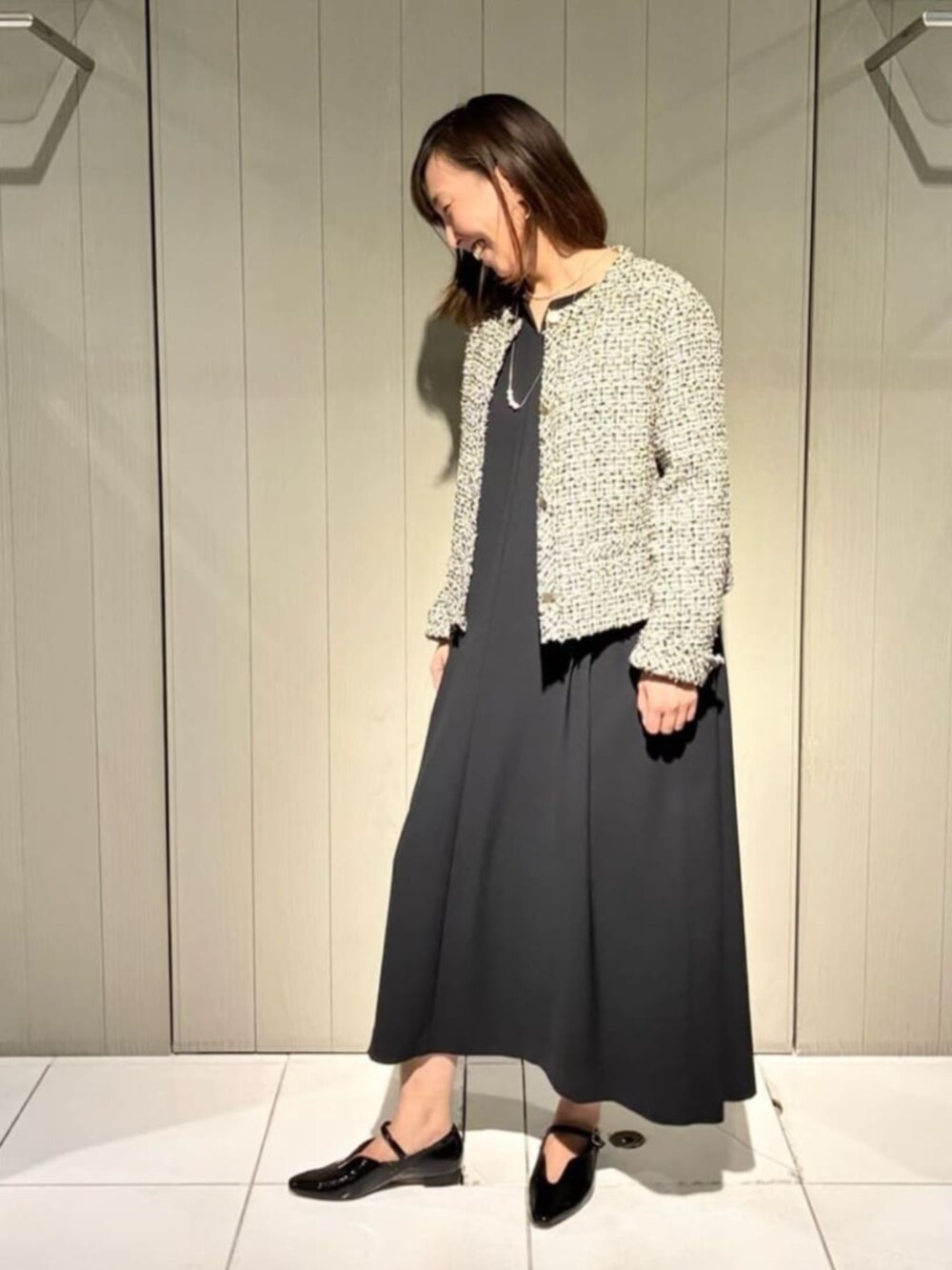 ベージュ系のノーカラージャケット、ブラック系のワンピース、ブラック系のパンプスを着用したレディースの冬コーディネートの3枚目の写真