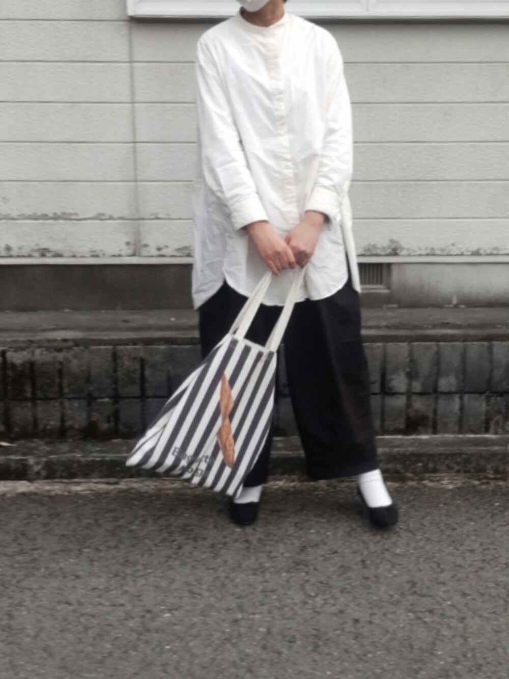 ブラック系のトートバッグを着用したレディースの春コーディネートの2枚目の写真