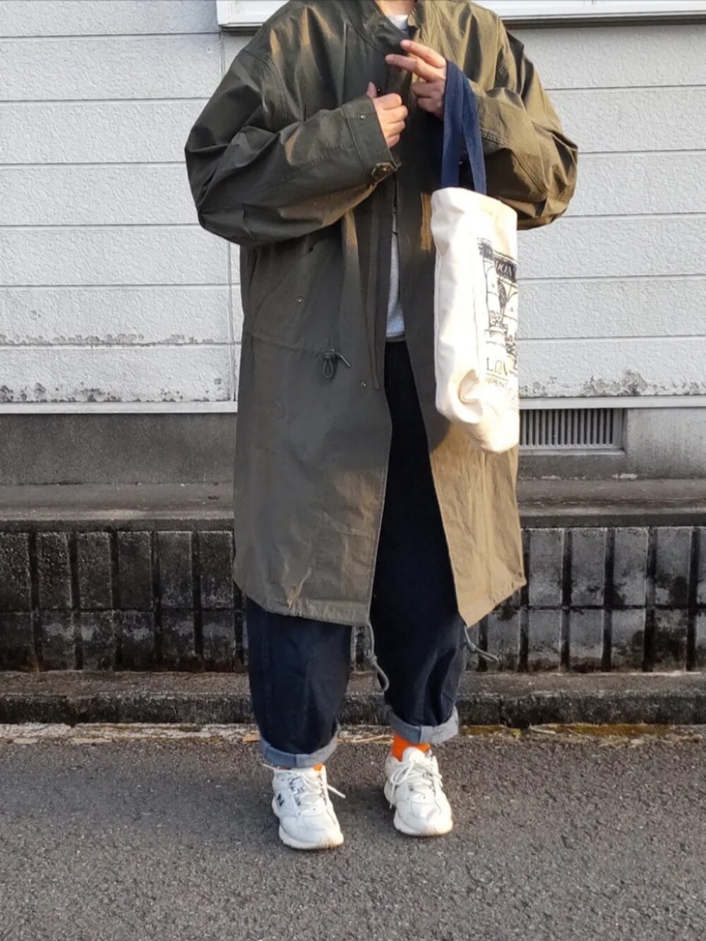 グリーン系のモッズコート、ホワイト系のスニーカーを着用したレディースの冬コーディネートの2枚目の写真