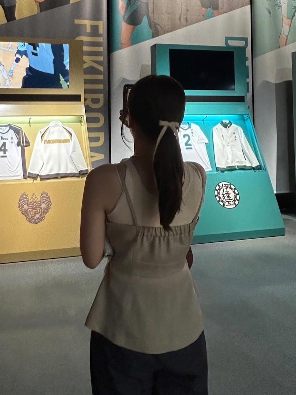 ベージュ系のキャミソール、ベージュ系のトップス、ブラウン系のハンドバッグを着用したレディースの夏コーディネートの2枚目の写真