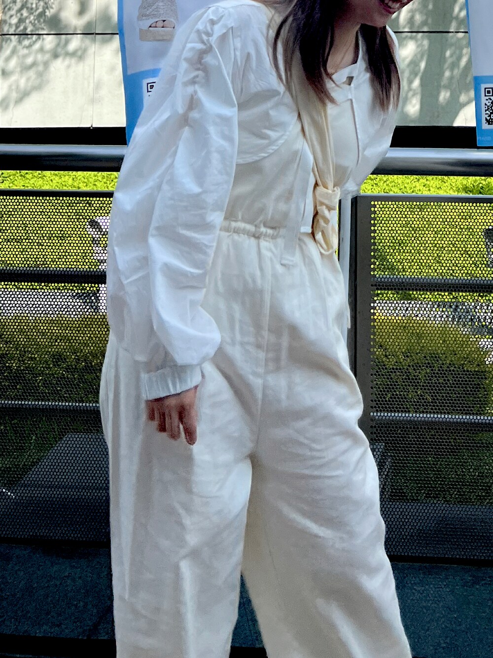 ホワイト系のサロペット/オーバーオール、ホワイト系のショルダーバッグ、グリーン系のキャミソールを着用したレディースの春コーディネートの3枚目の写真