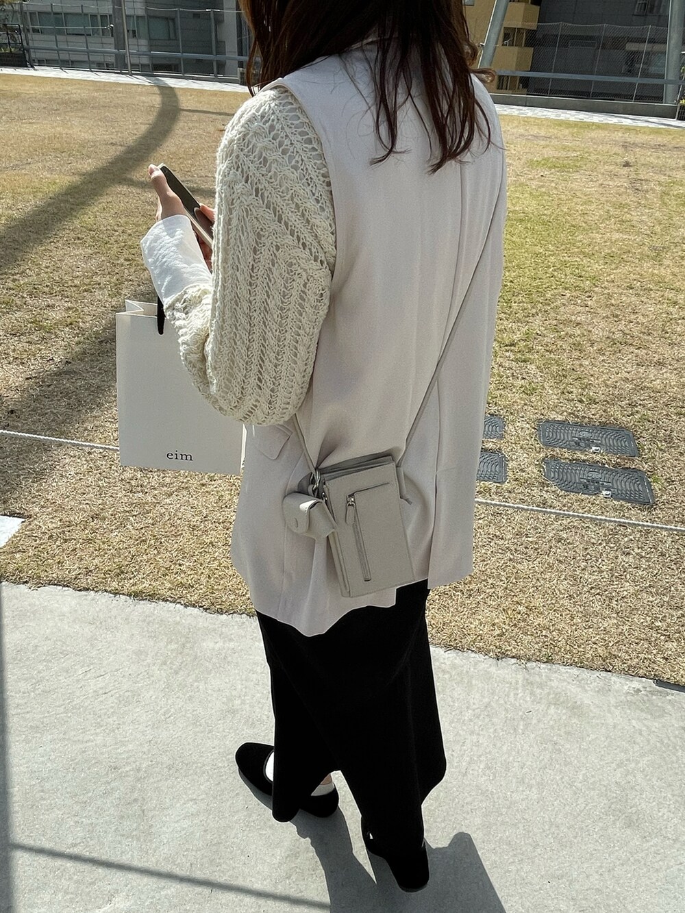 ホワイト系のその他アウター、ホワイト系のニット/セーター、ホワイト系のショルダーバッグを着用したレディースの春コーディネートの2枚目の写真