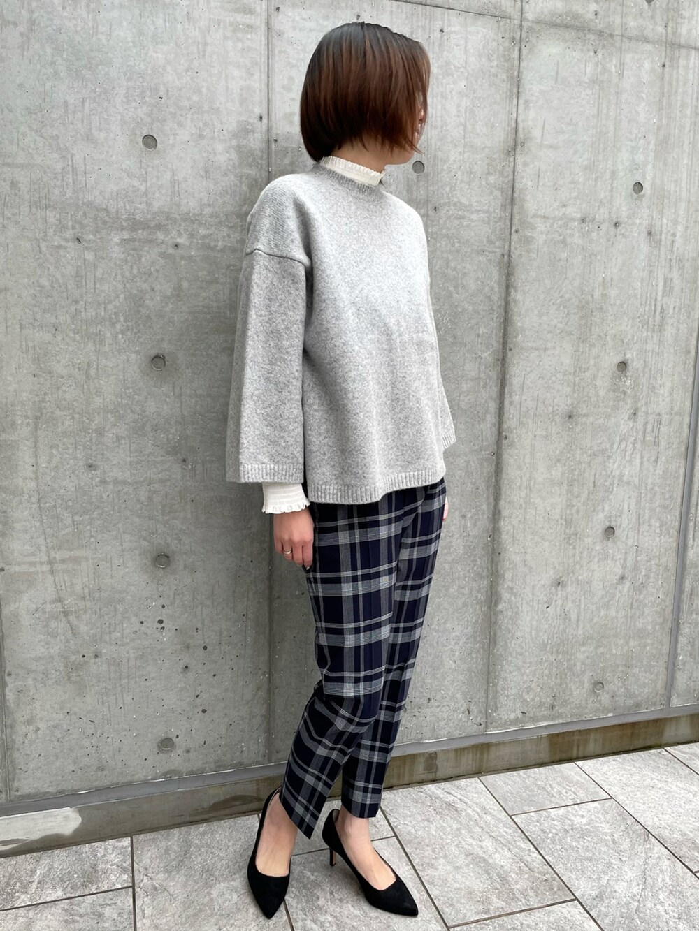 グレー系のニット/セーター、その他のパンツ、ホワイト系のシャツ/ブラウスを着用したレディースの冬コーディネートの4枚目の写真