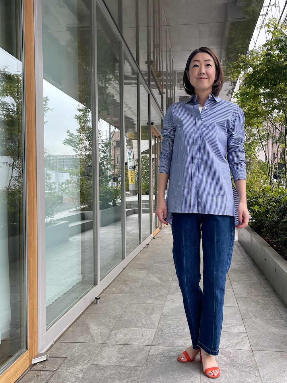 ブルー系のシャツ/ブラウス、ブルー系のデニムパンツ、ホワイト系のTシャツ/カットソーを着用したレディースの春コーディネートの2枚目の写真