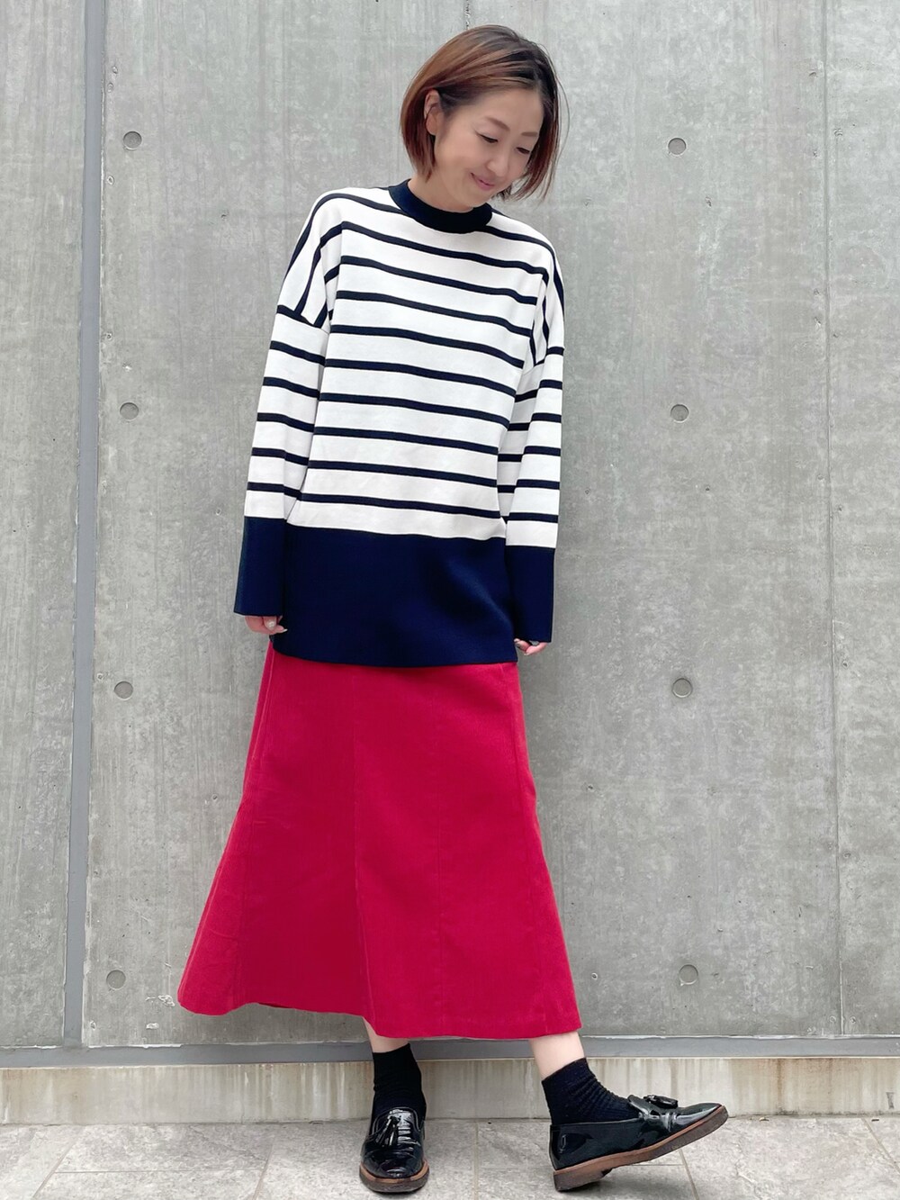 ホワイト系のニット/セーター、レッド系のスカート、その他のニット/セーターを着用したレディースの秋コーディネートの2枚目の写真