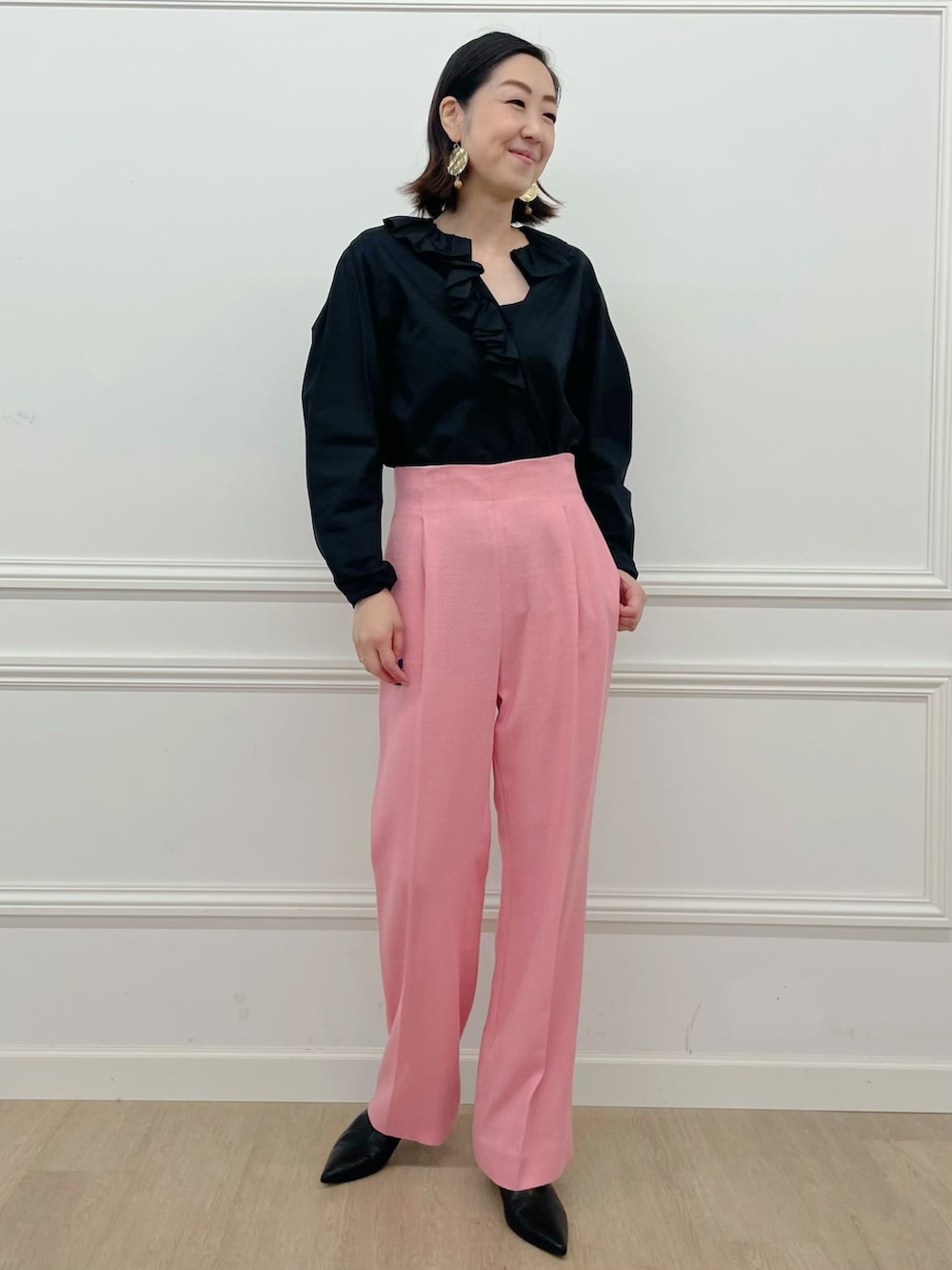 ブラック系のシャツ/ブラウス、ピンク系のパンツを着用したレディースの夏コーディネートの2枚目の写真