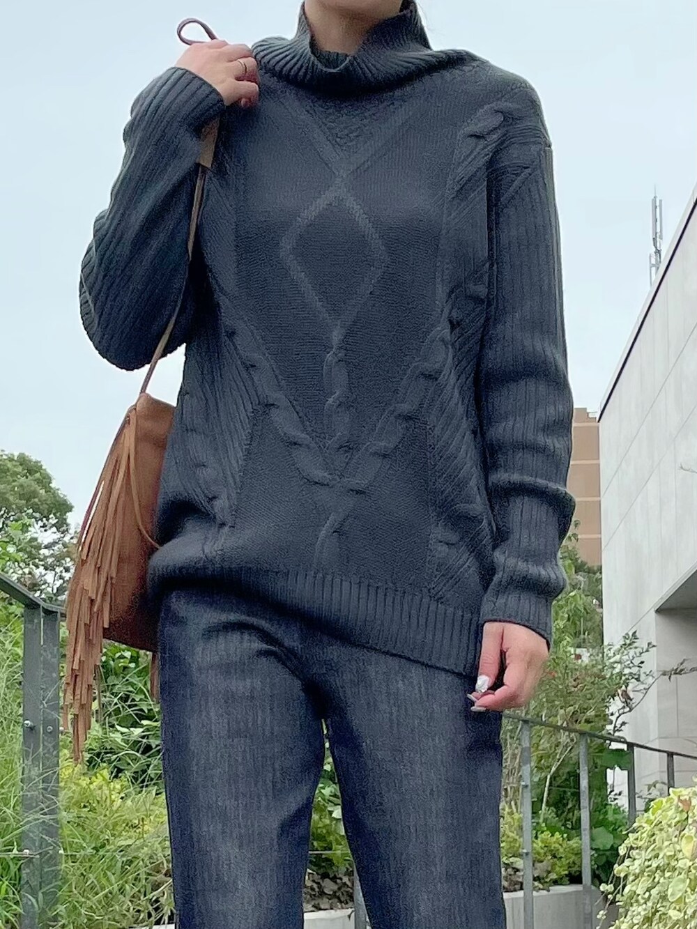 グレー系のニット/セーター、その他のデニムパンツを着用したレディースの秋コーディネートの2枚目の写真