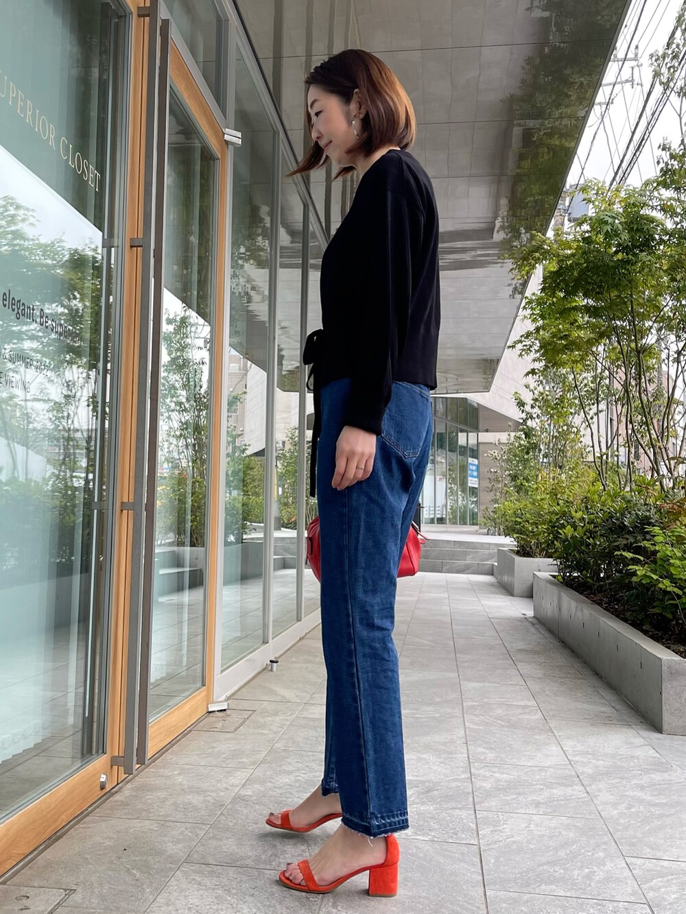 ブラック系のカーディガン/ボレロ、ブルー系のデニムパンツ、ホワイト系のTシャツ/カットソーを着用したレディースの春コーディネートの2枚目の写真