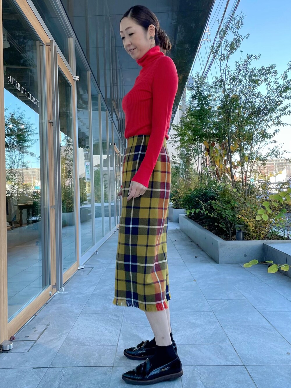 レッド系のニット/セーター、イエロー系のスカート、レッド系のニット/セーターを着用したレディースの冬コーディネートの2枚目の写真