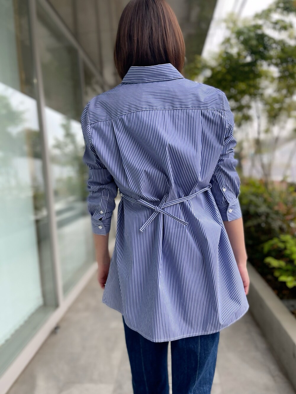 ブルー系のシャツ/ブラウス、ブルー系のデニムパンツ、ホワイト系のTシャツ/カットソーを着用したレディースの春コーディネートの4枚目の写真