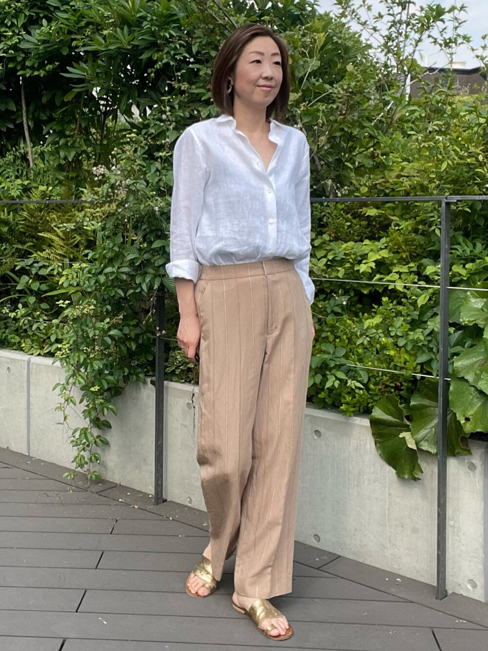 ホワイト系のシャツ/ブラウス、ベージュ系のパンツ、ホワイト系のシャツ/ブラウスを着用したレディースの夏コーディネートの3枚目の写真