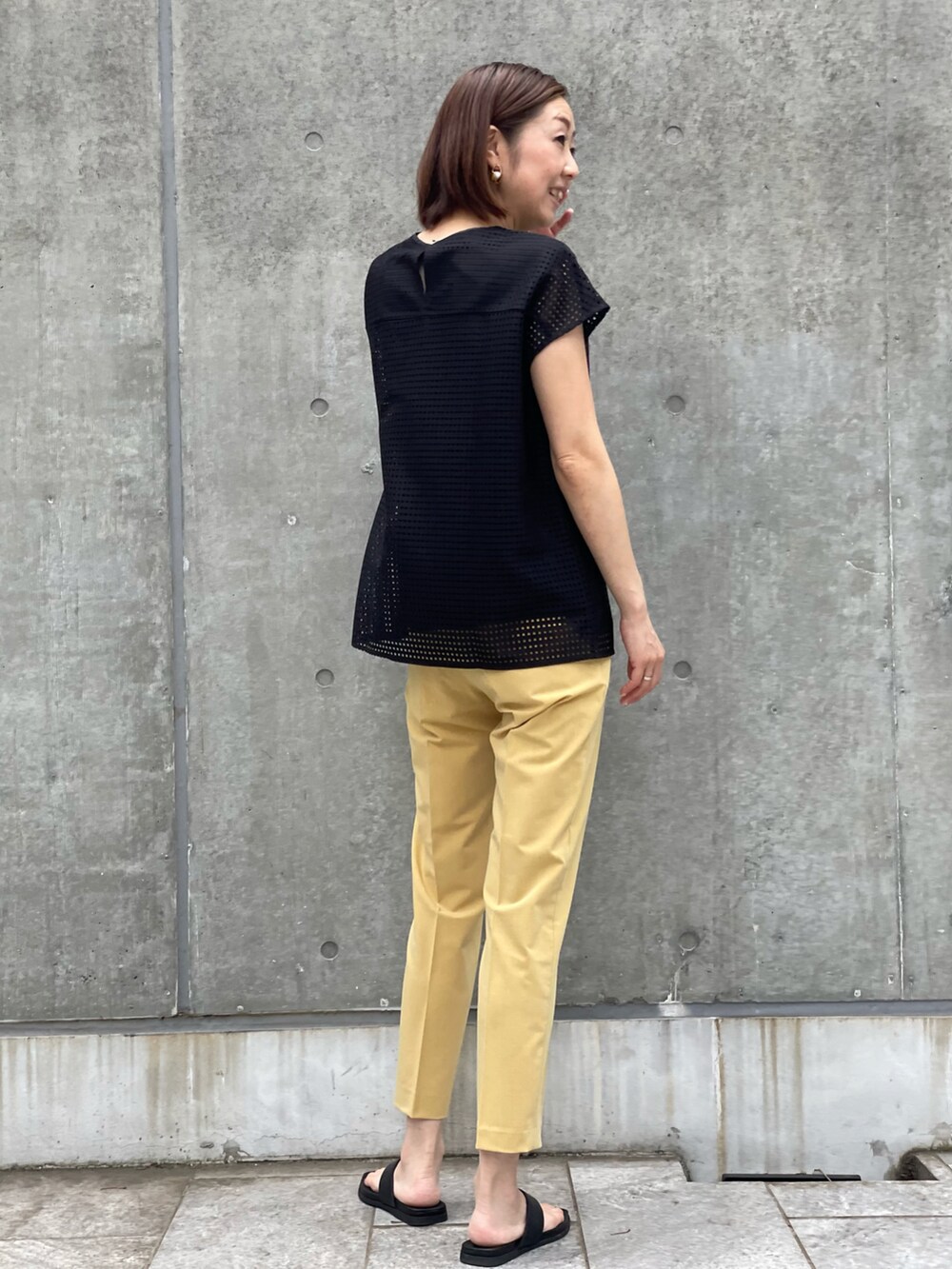 ブラック系のシャツ/ブラウス、イエロー系のパンツ、ブラック系のシャツ/ブラウスを着用したレディースの夏コーディネートの3枚目の写真