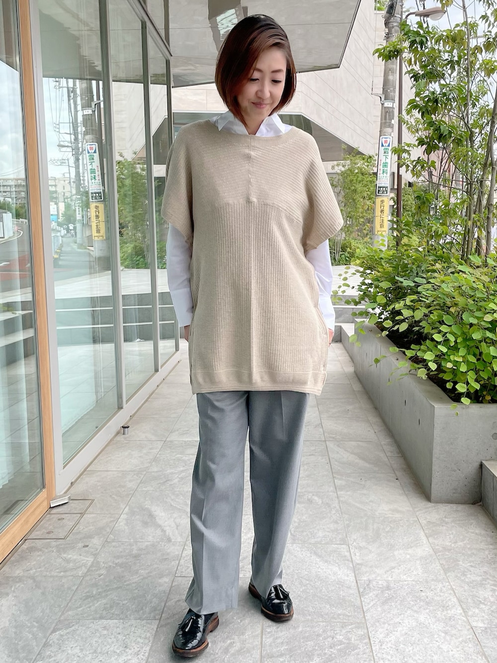 ベージュ系のトップス、ホワイト系のシャツ/ブラウス、グレー系のパンツを着用したレディースの秋コーディネートの4枚目の写真