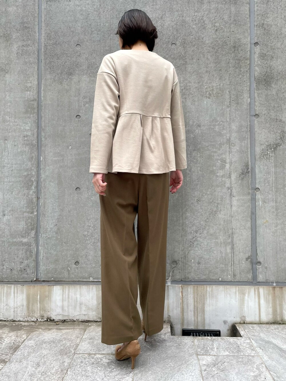 ブラウン系のパンツ、ベージュ系のTシャツ/カットソーを着用したレディースの冬コーディネートの2枚目の写真