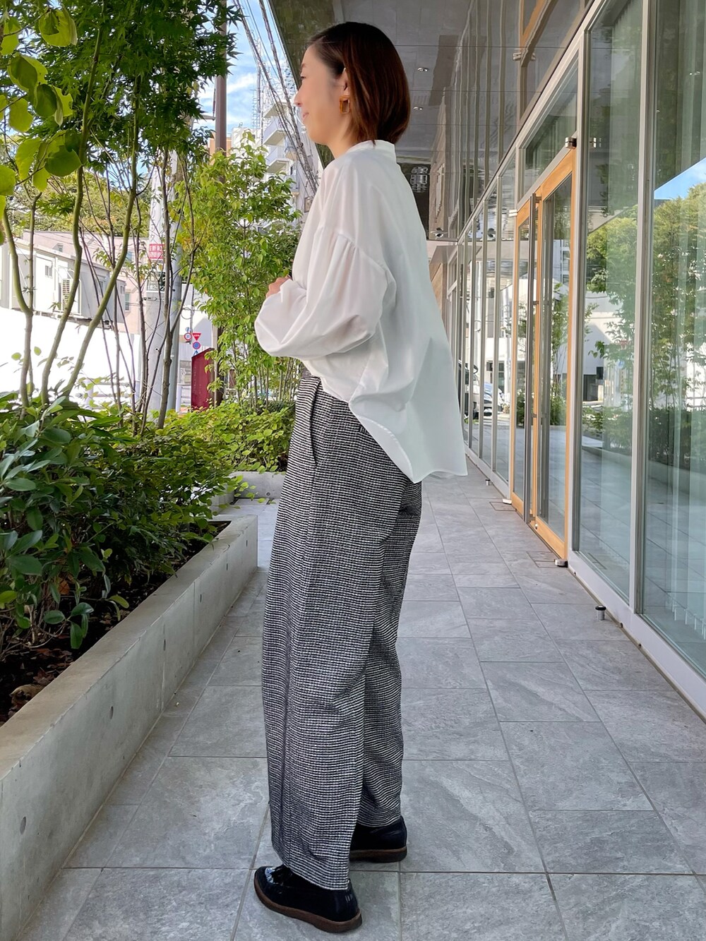 ホワイト系のシャツ/ブラウス、ブラック系のパンツを着用したレディースの秋コーディネートの3枚目の写真