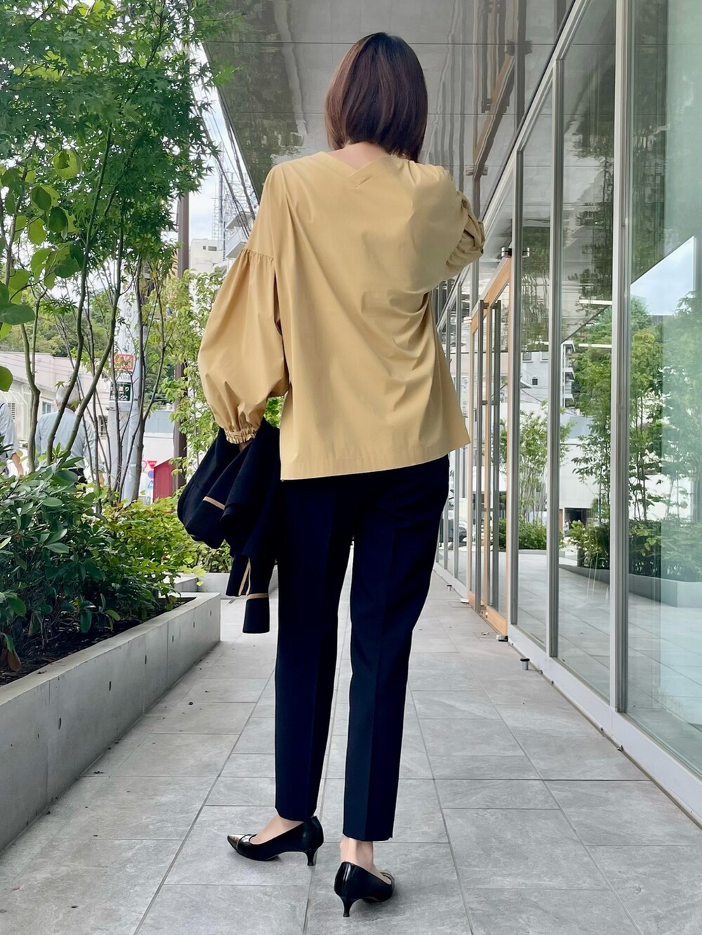 ベージュ系のシャツ/ブラウス、ブラック系のパンツ、ブラック系のカーディガン/ボレロを着用したレディースの秋コーディネートの2枚目の写真