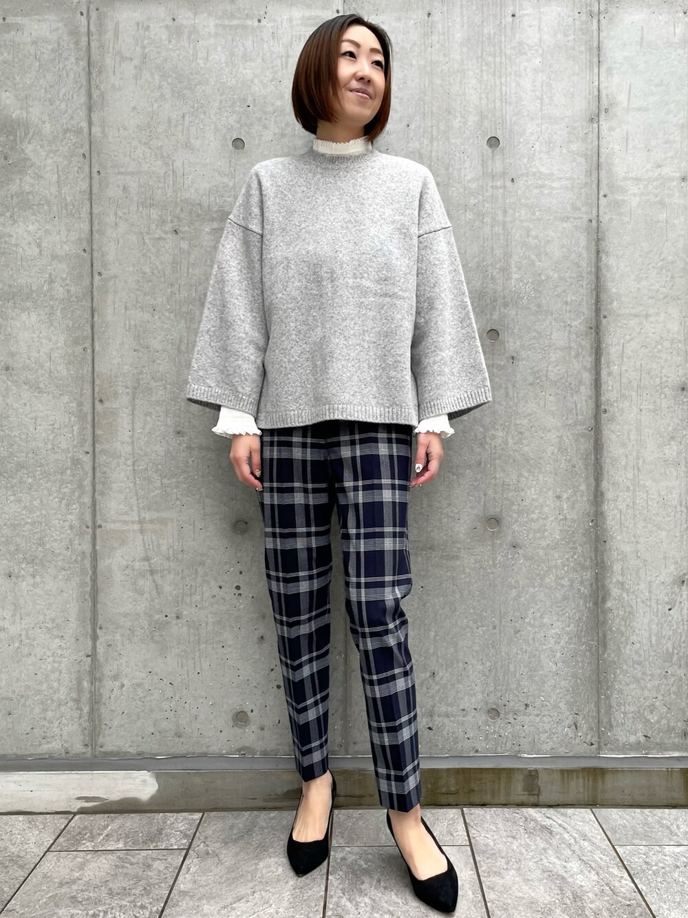 グレー系のニット/セーター、その他のパンツ、ホワイト系のシャツ/ブラウスを着用したレディースの冬コーディネートの2枚目の写真