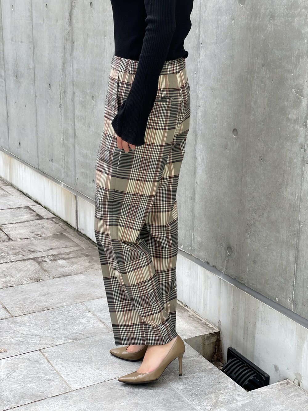 ブラック系のニット/セーター、ベージュ系のパンツ、ブラック系のTシャツ/カットソーを着用したレディースの秋コーディネートの4枚目の写真