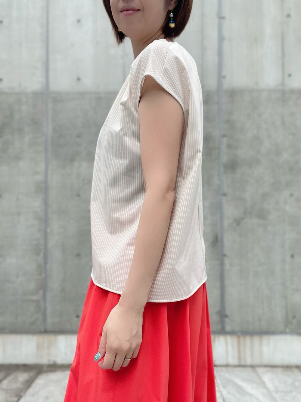 ベージュ系のTシャツ/カットソー、レッド系のスカート、レッド系のスカートを着用したレディースの夏コーディネートの5枚目の写真