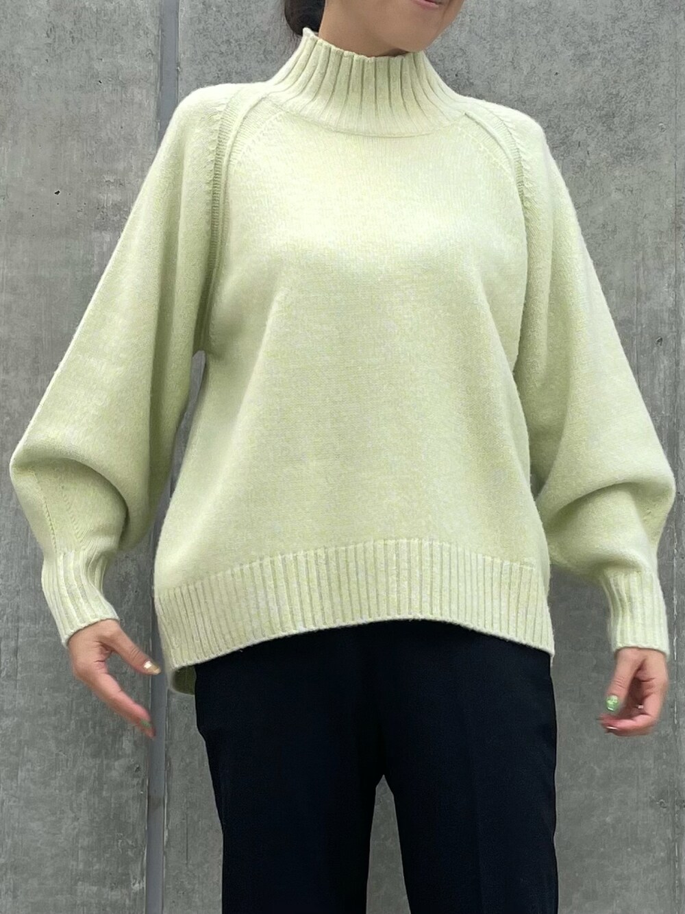 イエロー系のニット/セーター、ブラック系のパンツ、イエロー系のニット/セーターを着用したレディースの冬コーディネートの3枚目の写真