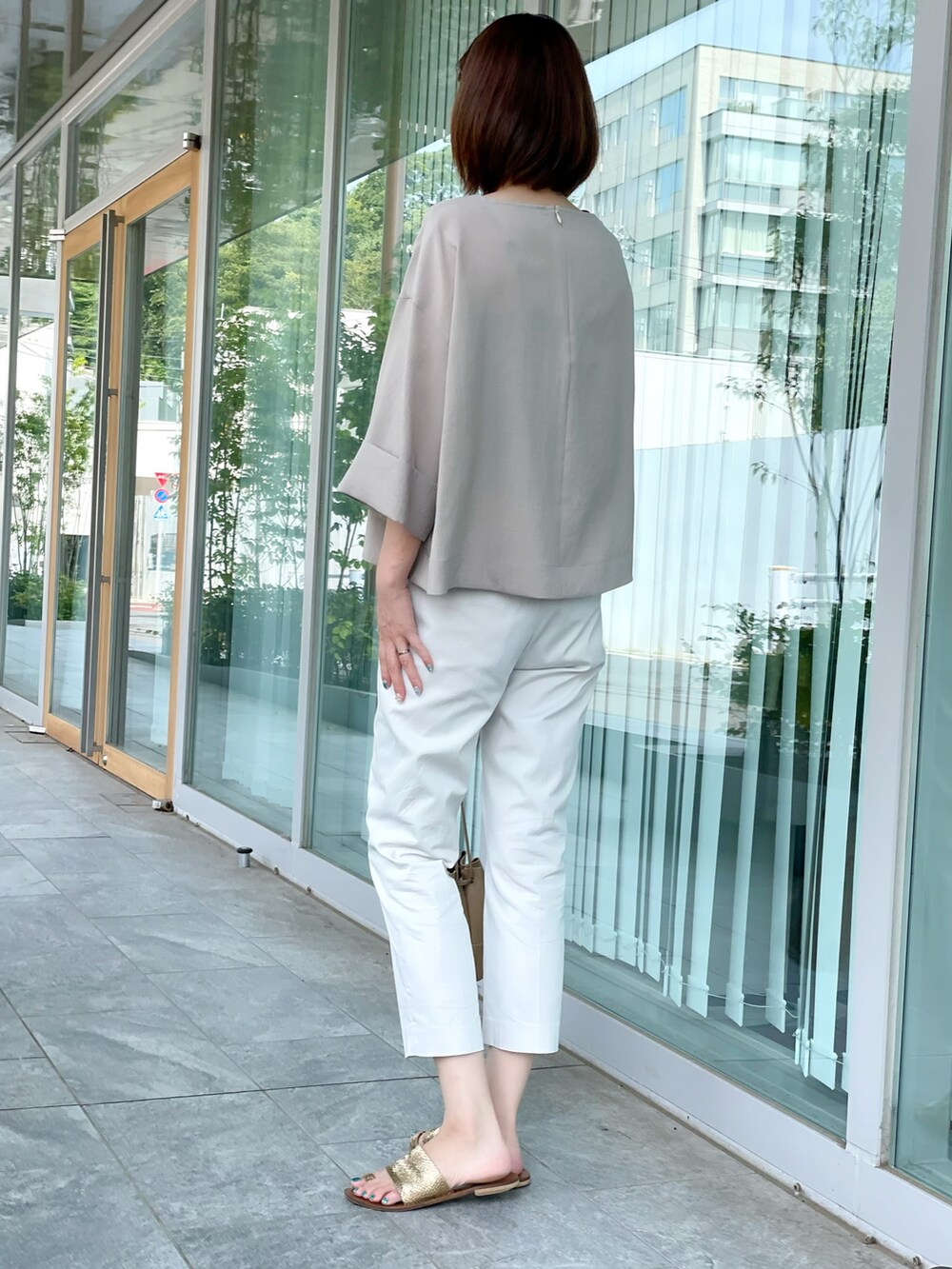 ベージュ系のシャツ/ブラウス、グレー系のパンツを着用したレディースの夏コーディネートの3枚目の写真