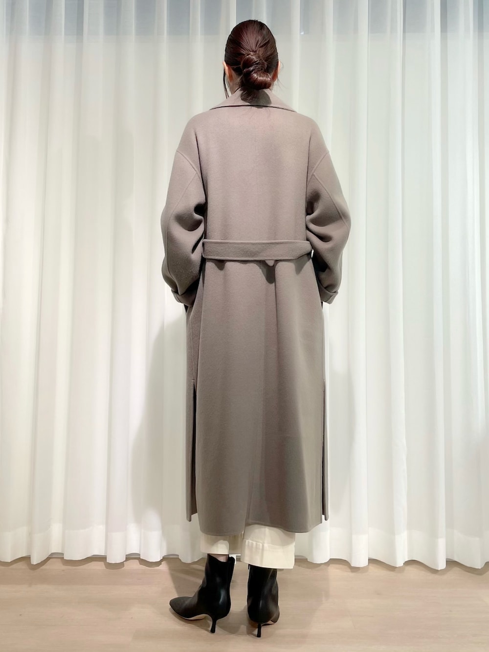 ブラック系のニット/セーター、ホワイト系のデニムパンツ、グリーン系のジャケット/アウターを着用したレディースの冬コーディネートの3枚目の写真