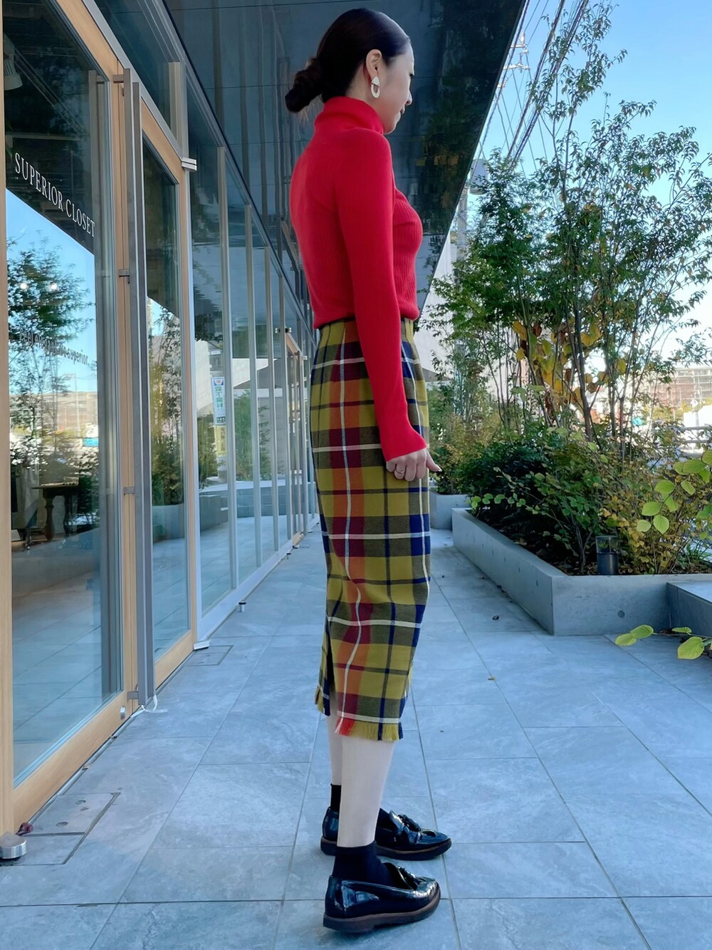 レッド系のニット/セーター、イエロー系のスカート、レッド系のニット/セーターを着用したレディースの冬コーディネートの4枚目の写真