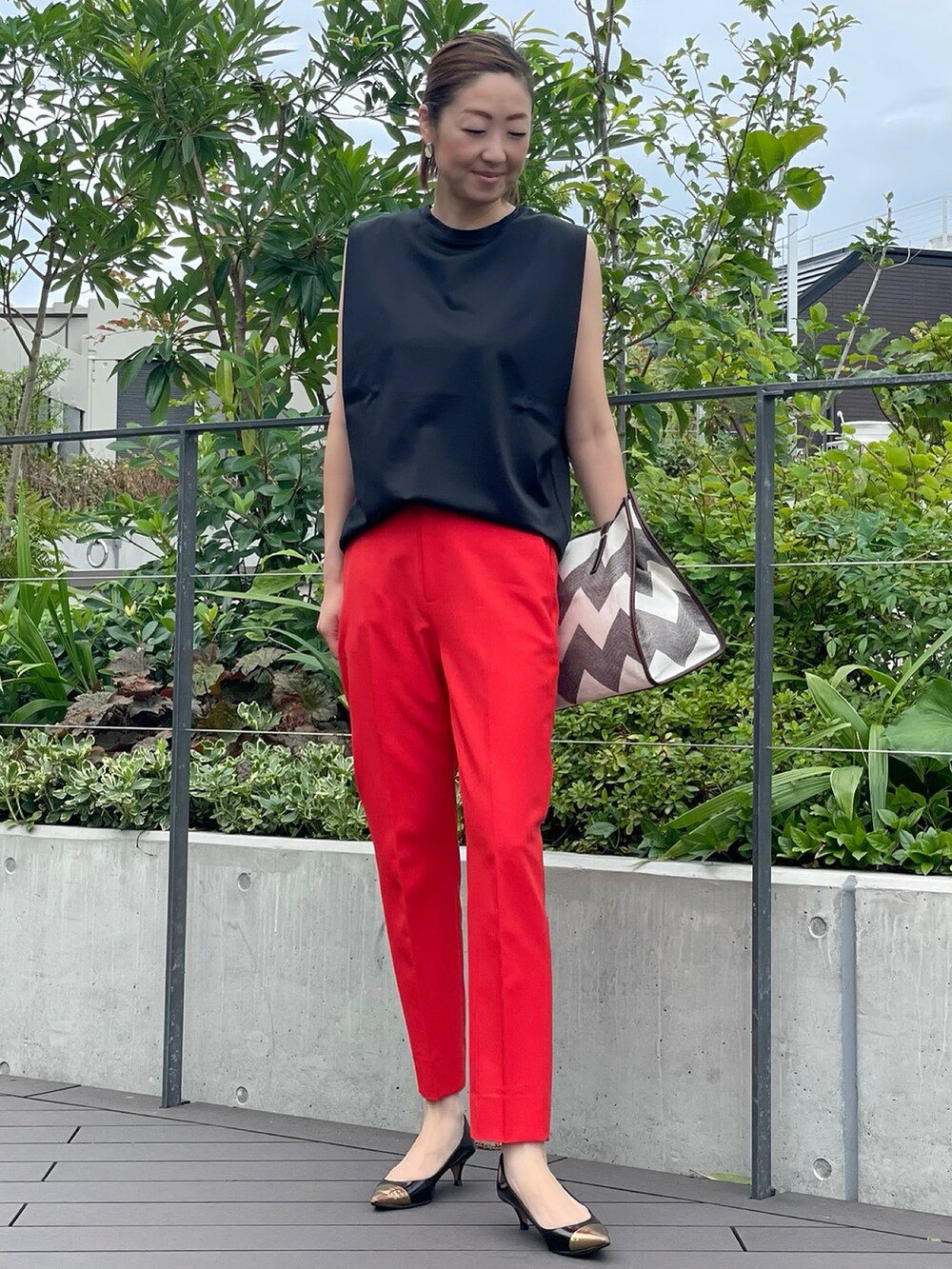 ブラック系のTシャツ/カットソー、レッド系のパンツ、ブラック系のTシャツ/カットソーを着用したレディースの夏コーディネートの2枚目の写真